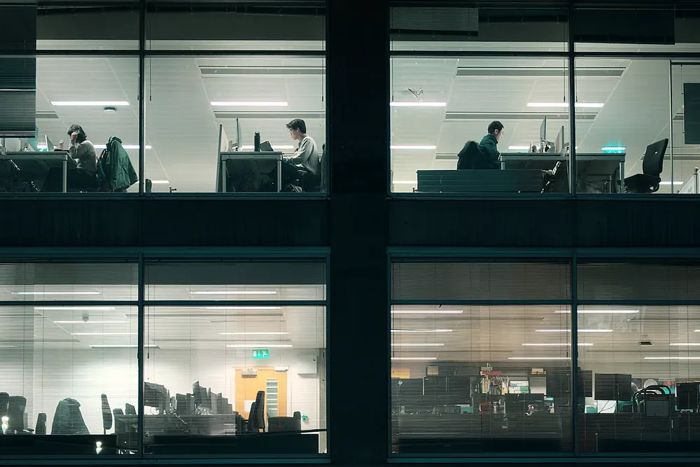 Office floors lit at night with people at work